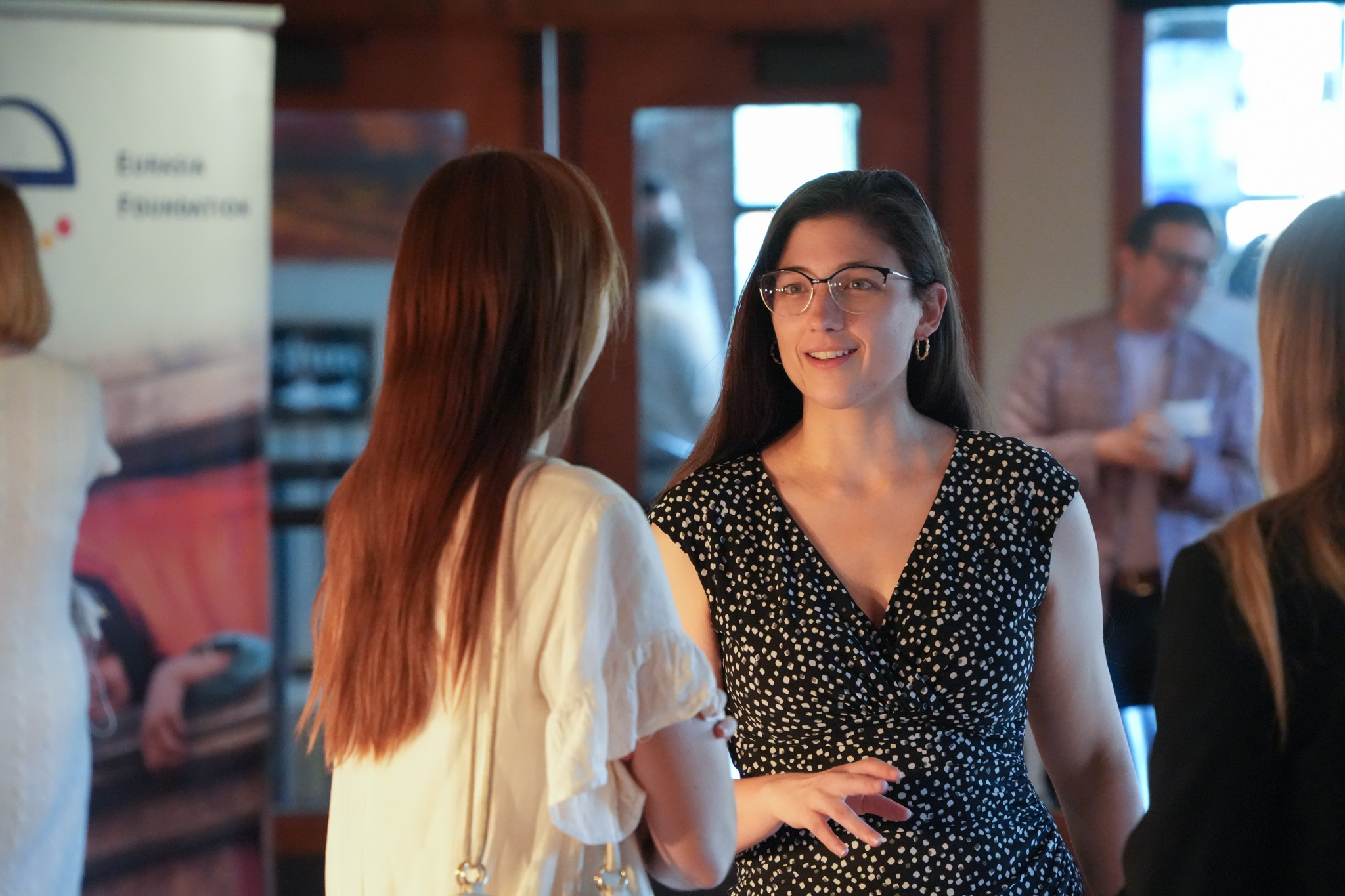 Two YPN fellows talk at the closing ceremony. A banner with the Eurasia Foundation logo is visible in the background.